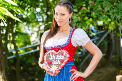 Frau im Dirndl mit geschnürtem Mieder und Schürze
